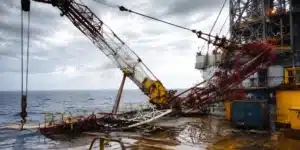 Offshore crane lifting heavy equipment onto an oil platform during maritime operations.